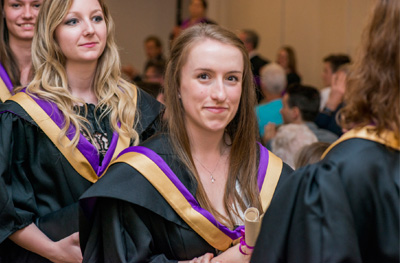 New graduates collect their scrolls