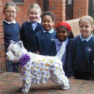 schoolchildren pose with decorated mannequin